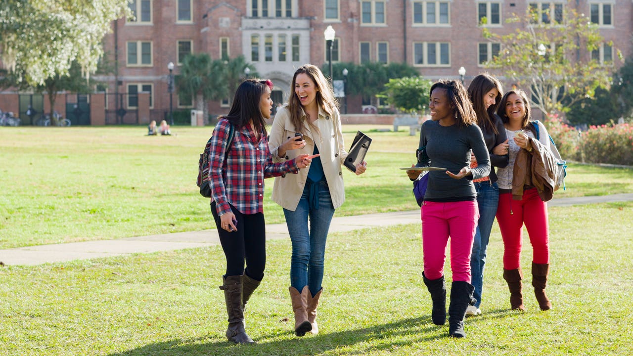 group of college students walking on a campus quad