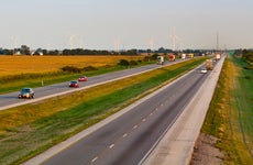 Highway in the countryside with cars and windpower generators.