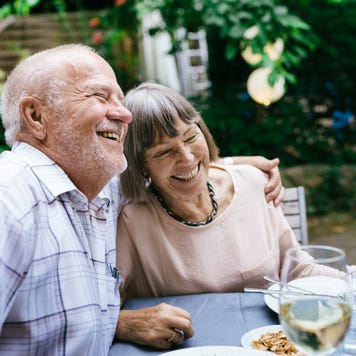 A smiling older couple dining outside