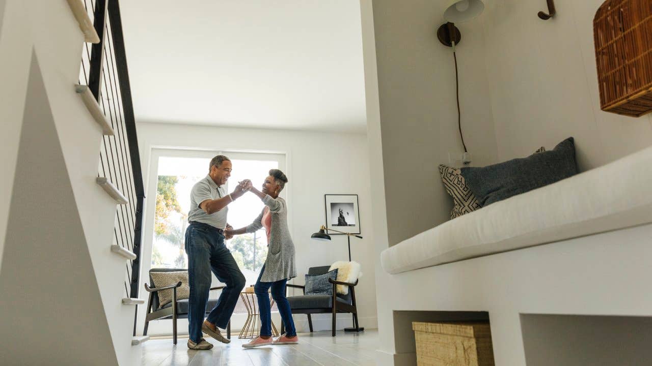 An older couple dancing in their home