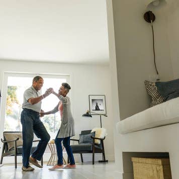 An older couple dancing in their home