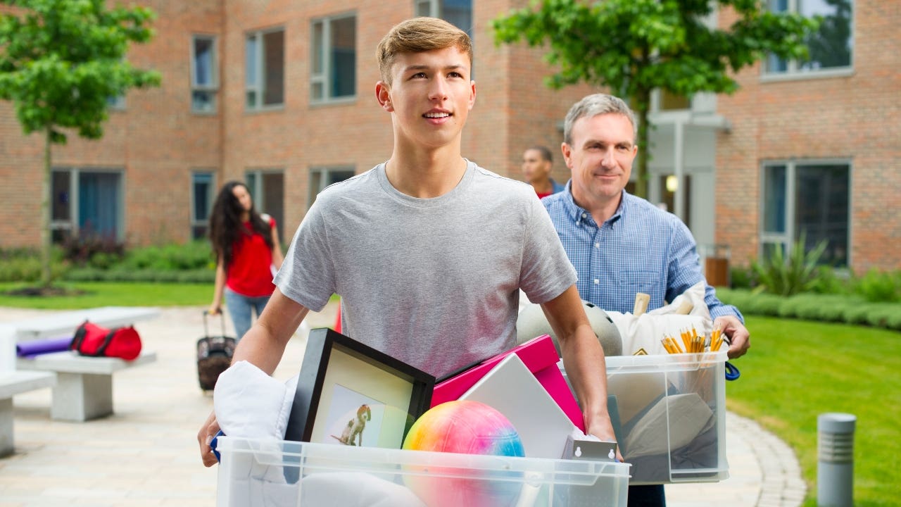 Man and son carry boxes to dorm room