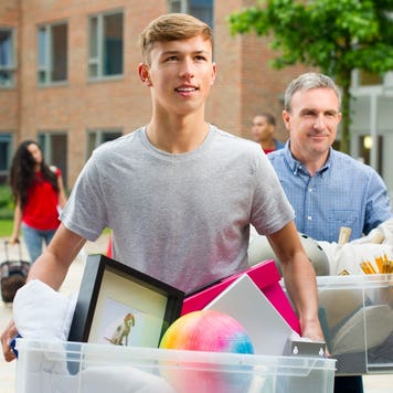 Man and son carry boxes to dorm room