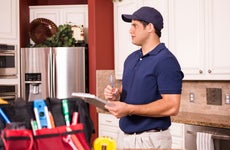 Home appraiser with clipboard assessing a large kitchen