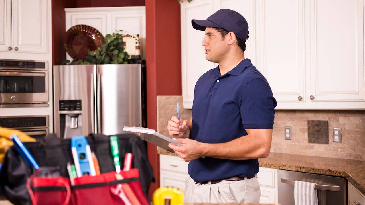 Home appraiser with clipboard assessing a large kitchen