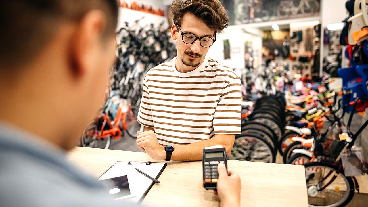 A man is buying a bicycle in a bicycle shop