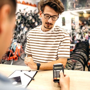 A man is buying a bicycle in a bicycle shop