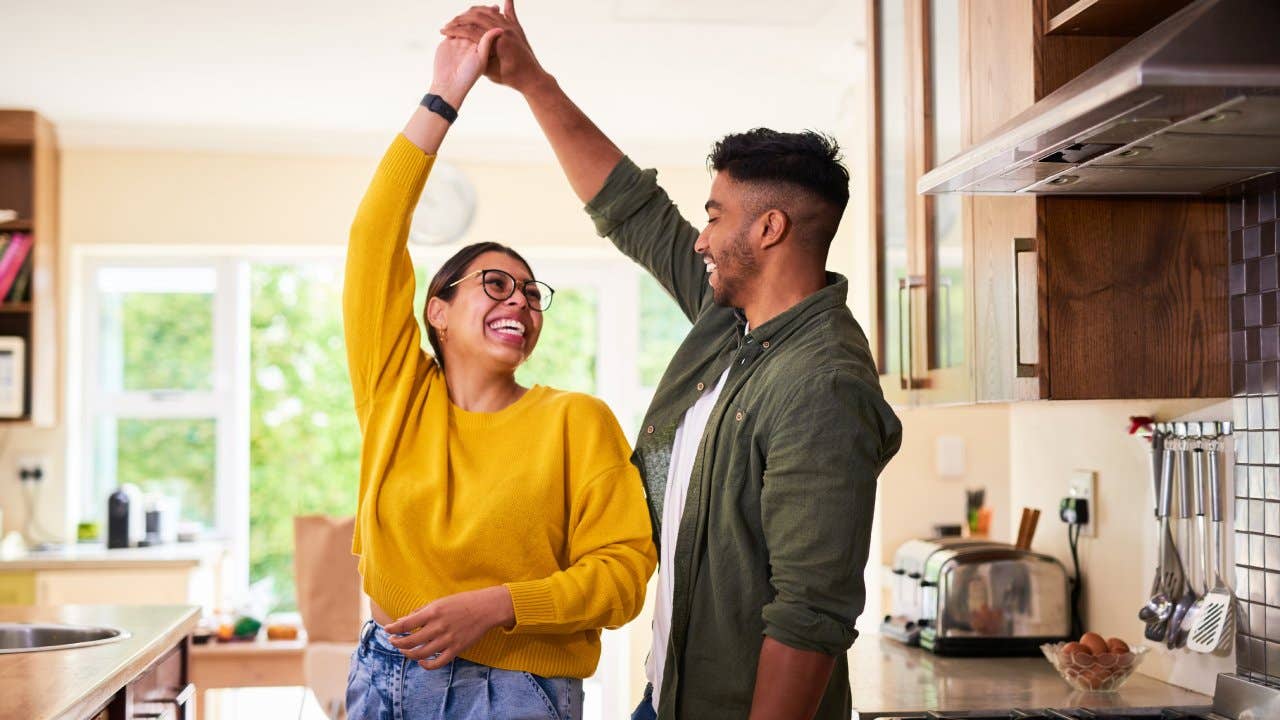 A young couple dancing together in their kitchen