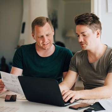 Two men sit with paperwork at a table