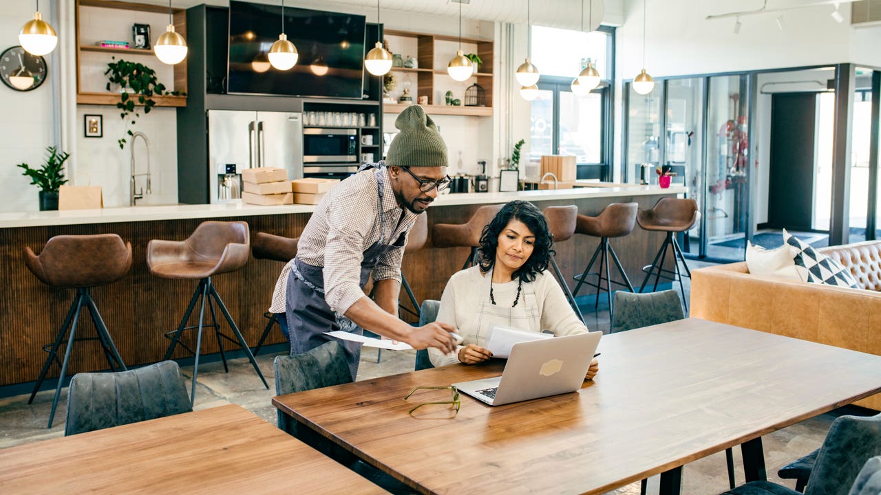 two people looking at computer and discussing business matters in a shop