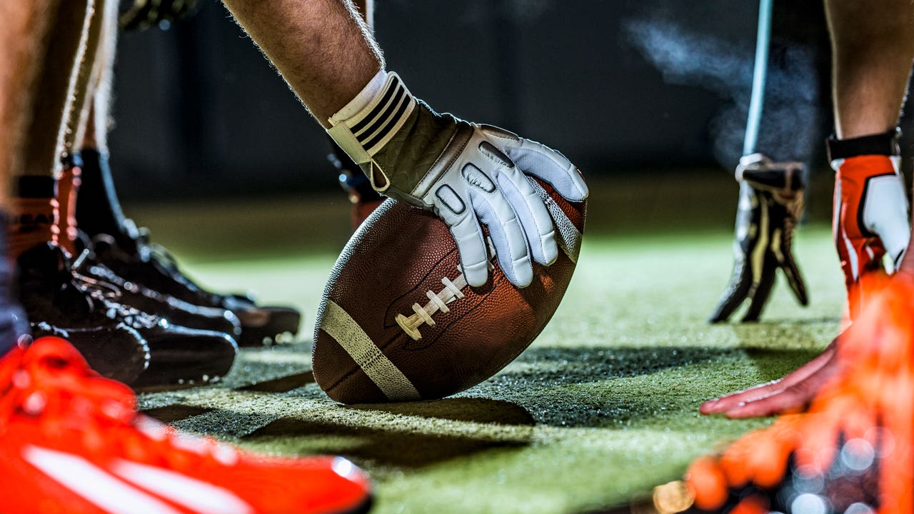 close up shot of a football player about to snap the ball