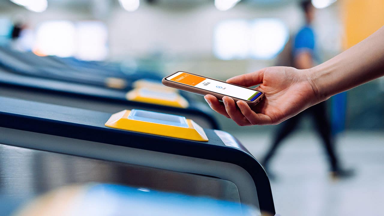 person using tap to pay to enter a subway