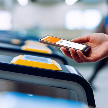 person using tap to pay to enter a subway