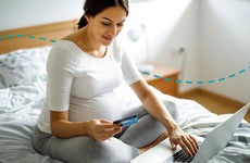 Young pregnant woman shopping online with credit card