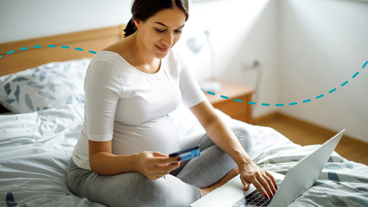 Young pregnant woman shopping online with credit card