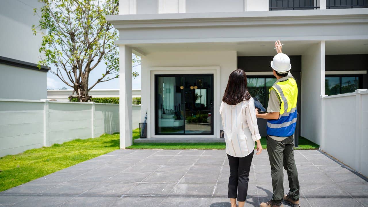 Building inspector and woman standing outside of a building