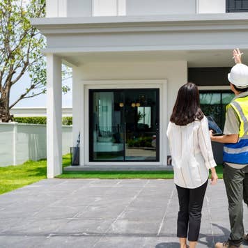 Building inspector and woman standing outside of a building