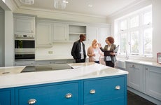 couple with a realtor looking at the kitchen in a house for sale
