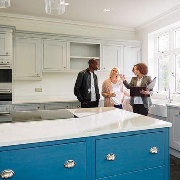 couple with a realtor looking at the kitchen in a house for sale
