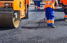 workers repairing a street and laying asphalt