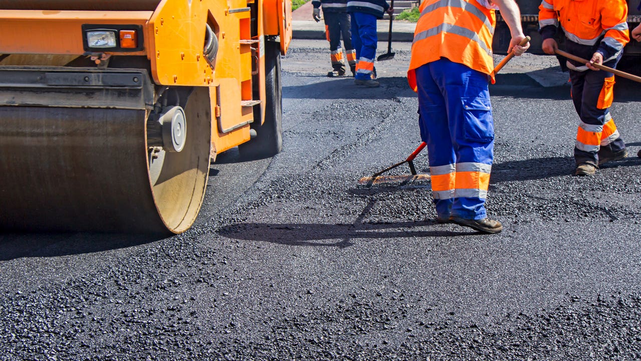 workers repairing a street and laying asphalt