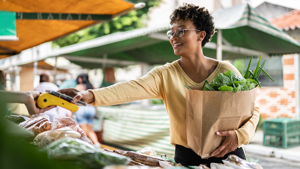 woman paying at a farmers market