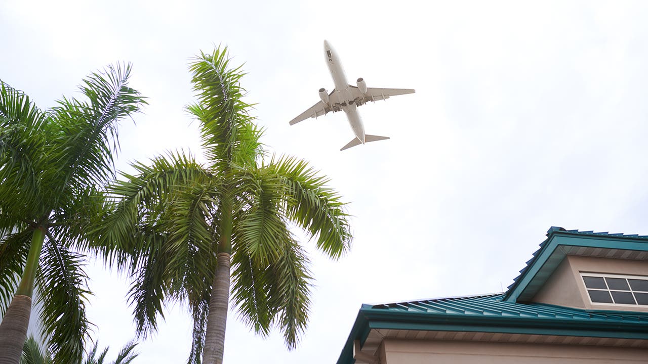 airplane flying over a house