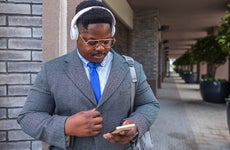 African young businessman with headphones on the street
