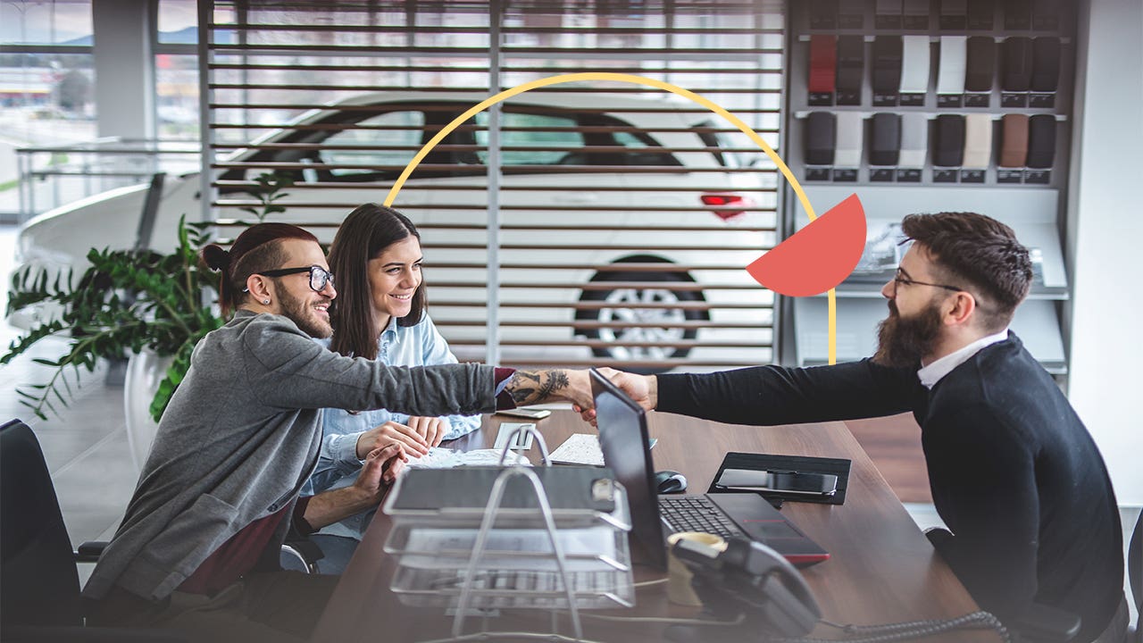 Man and woman sit on the left side of a desk opposite of a car dealership employee. The men are shaking hands across the desk and there is a thin yellow circle illustration behind them with a filled-in orange half circle.