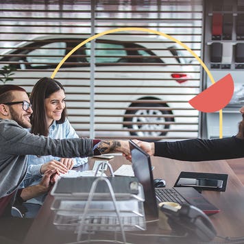 Man and woman sit on the left side of a desk opposite of a car dealership employee. The men are shaking hands across the desk and there is a thin yellow circle illustration behind them with a filled-in orange half circle.