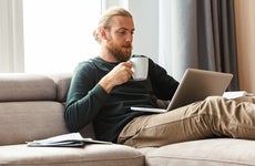 man sitting on the couch and working on laptop