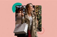 A woman doing Christmas shopping. There is a Christmas tree in the background and they are carrying a couple of shopping bags.