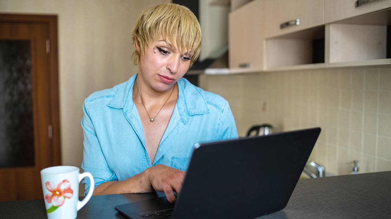 A transgender women using a laptop while surfing the net
