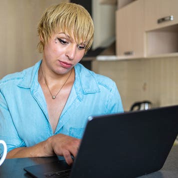 A transgender women using a laptop while surfing the net