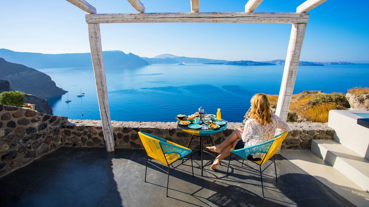 woman having breakfast outdoors with a view over the water