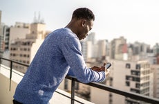 young man using his phone on a city rooftop