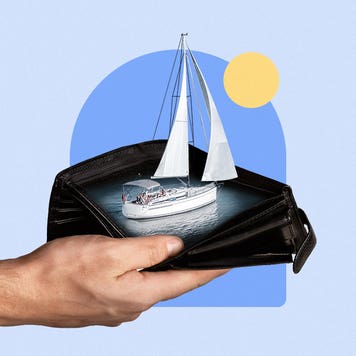 A hand holds a sailboat