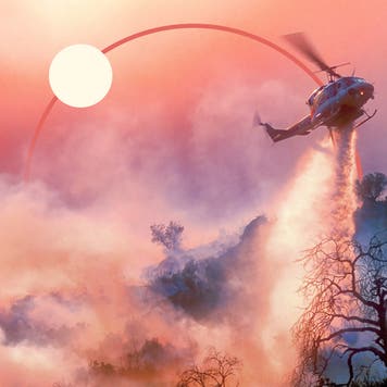 A helicopter dumping water on a forest fire.