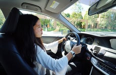 A young teenage girl sitting behind the wheel learning how to drive