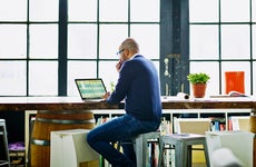 older man sitting down working on his computer