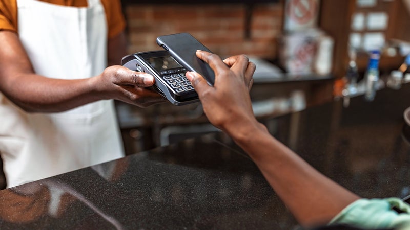 a close up shot of a person paying with their mobile wallet