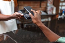 a close up shot of a person paying with their mobile wallet