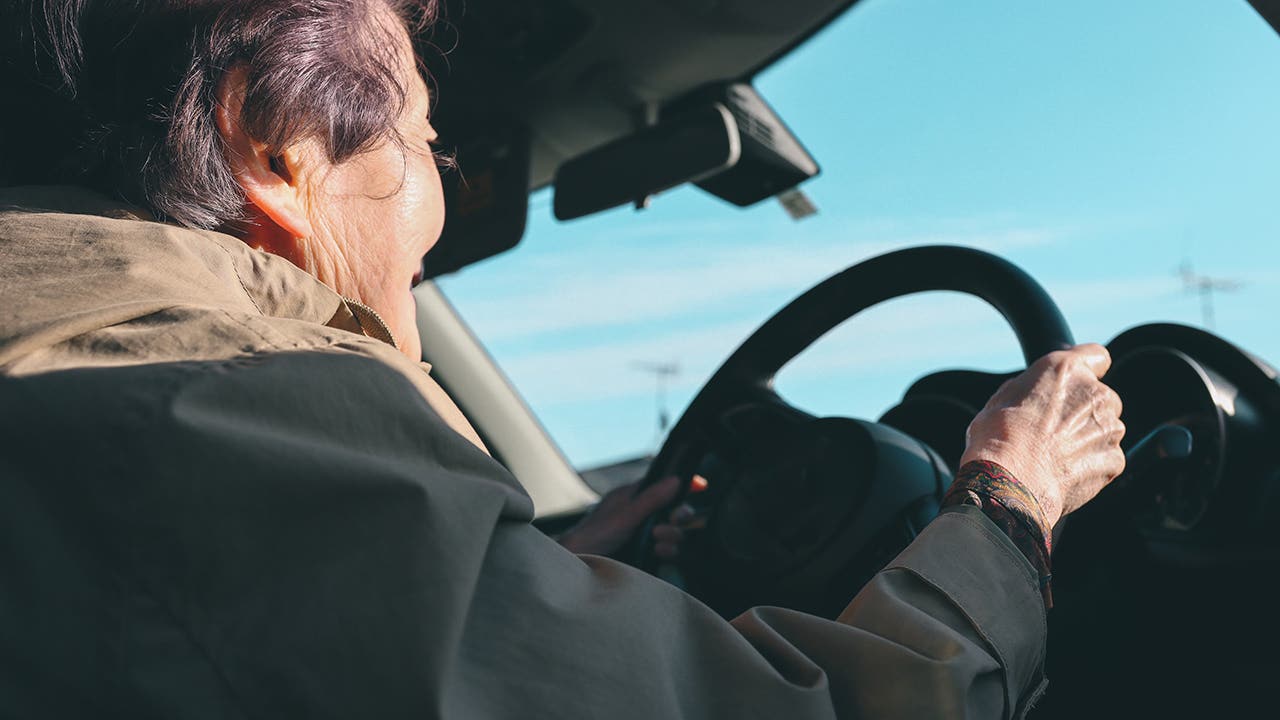 elderly woman driving a car