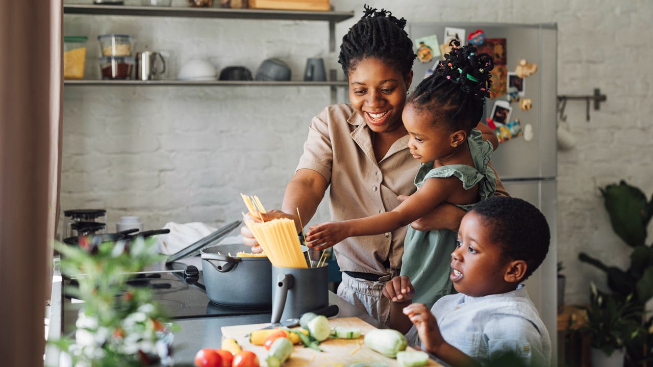 mother and two children cooking dinner at home