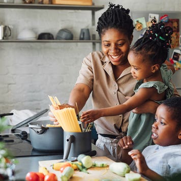 mother and two children cooking dinner at home