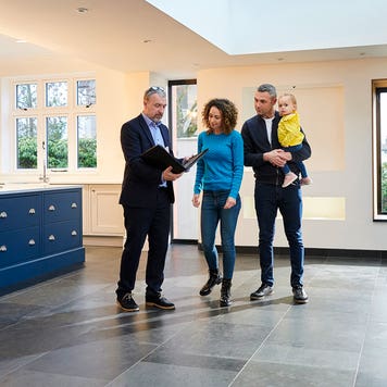 real estate agent showing a house to a family