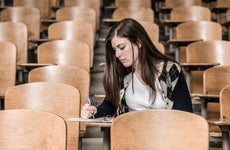 College student takes notes in a lecture hall