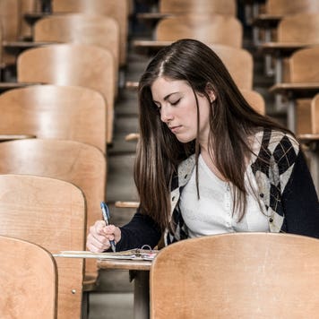 College student takes notes in a lecture hall