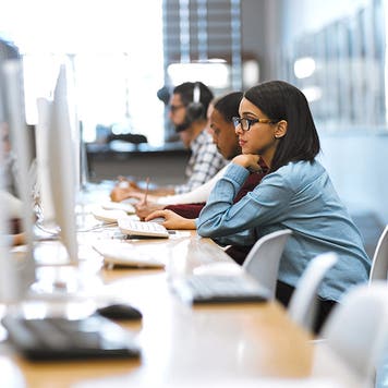 Shot of a group of university students working on computers in the library at campus