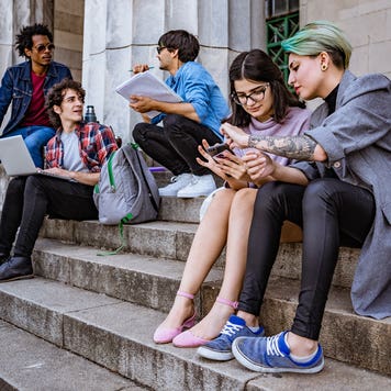 college students studying on some steps